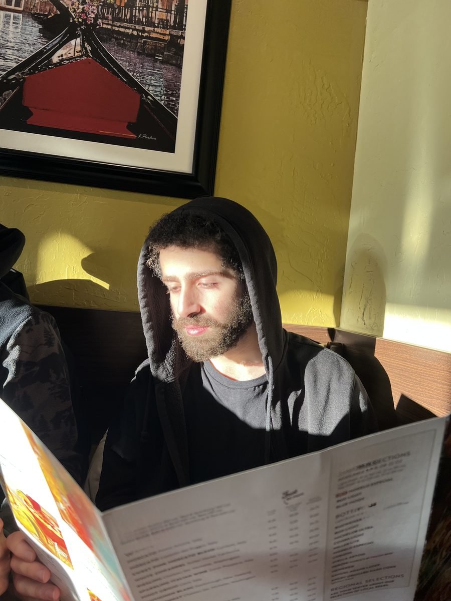 Ahmad Abu-Hattab reading at a restaurant in Toronto, Ontario — Engineering Physics student at McMaster University and CEO of City Centre Firm Corp